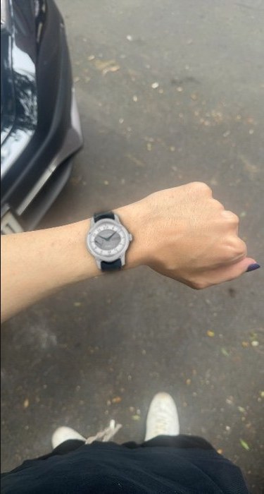 A photo-real try-on result: a watch rendered on a real wrist outdoors, strap wrapping naturally.